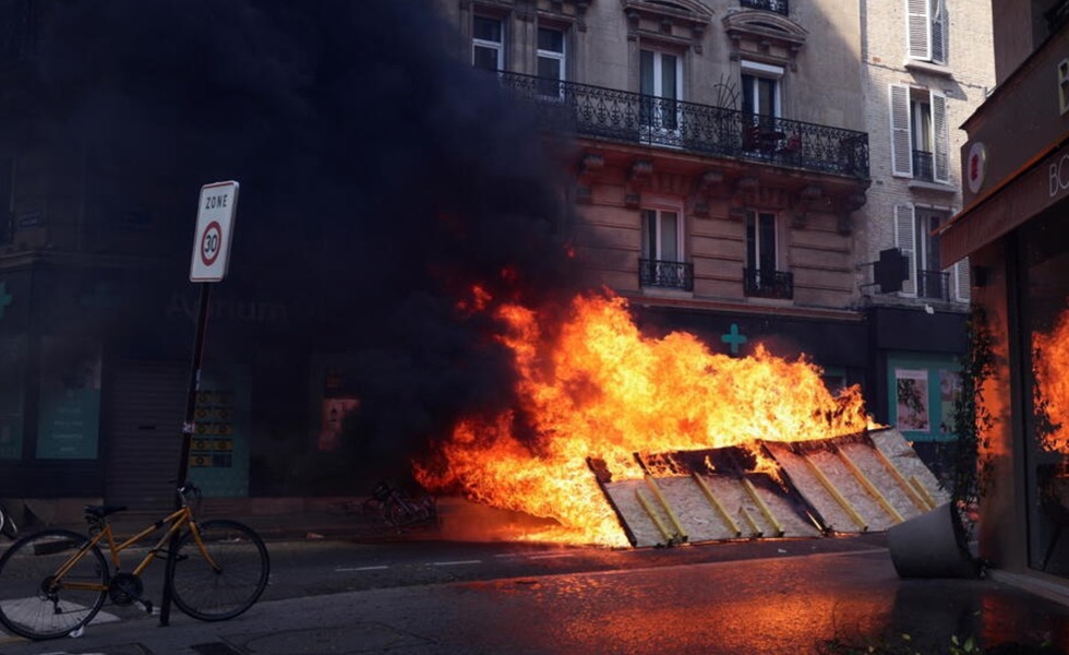 Une barricade et du mobilier urbain brûlent dans une rue de Paris pendant les débordements du défilé du 1er mai 2022.