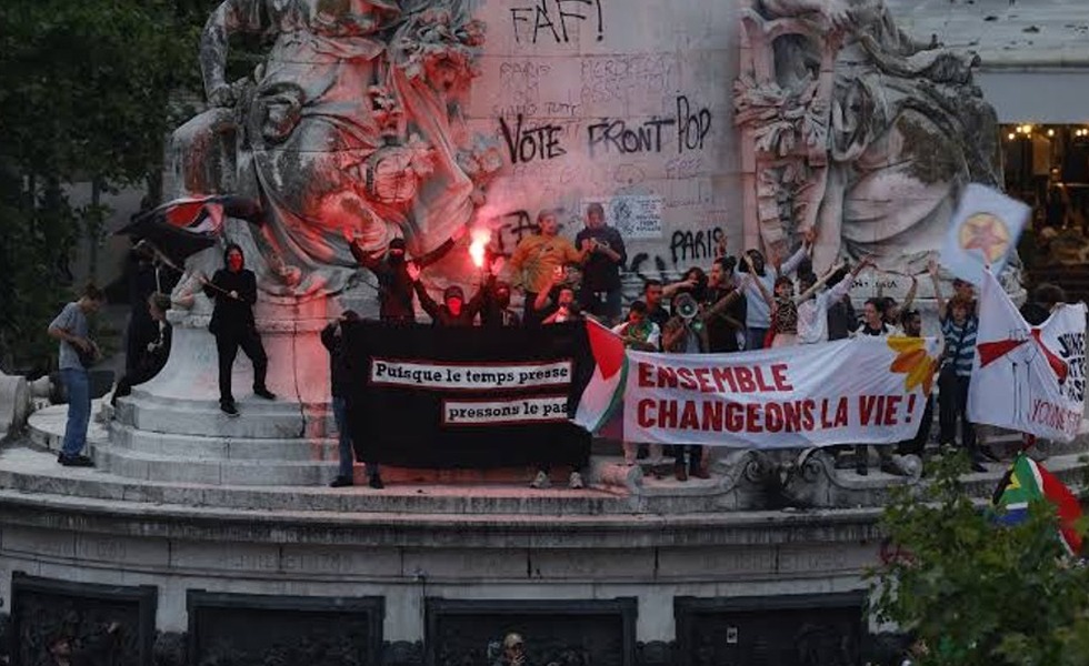 Des manifestants occupent le monument de la place de la République à Paris, entourés de banderoles, de graffitis et de fumigènes après l’annonce des résultats législatifs.