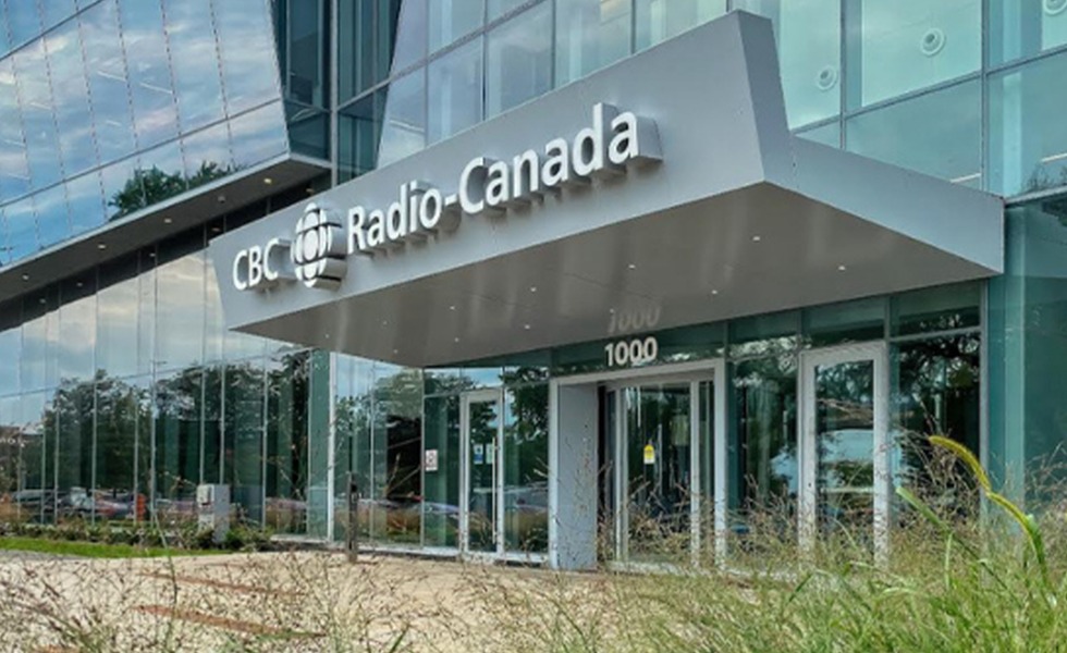 La façade vitrée et l’entrée principale de la Maison de Radio-Canada à Montréal; les vitres endommagées pendant l’incident ne sont pas visibles sur cette photo de contexte. Source : Radio-Canada, image publiée par True North.