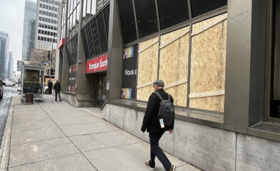 Les vitrines d’une succursale Scotiabank du centre-ville sont recouvertes de panneaux de bois au lendemain de la manifestation du 1er mai 2024. Photo : Martin Daigle / CityNews.