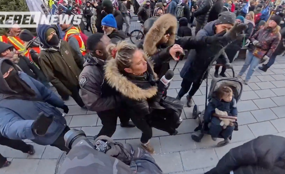 Une bousculade éclate autour d’une femme et d’une poussette tandis que des personnes masquées s’approchent de l’équipe de tournage. Capture vidéo de l’agression rapportée du vidéaste Guillaume Roy, Rebel News / YouTube.