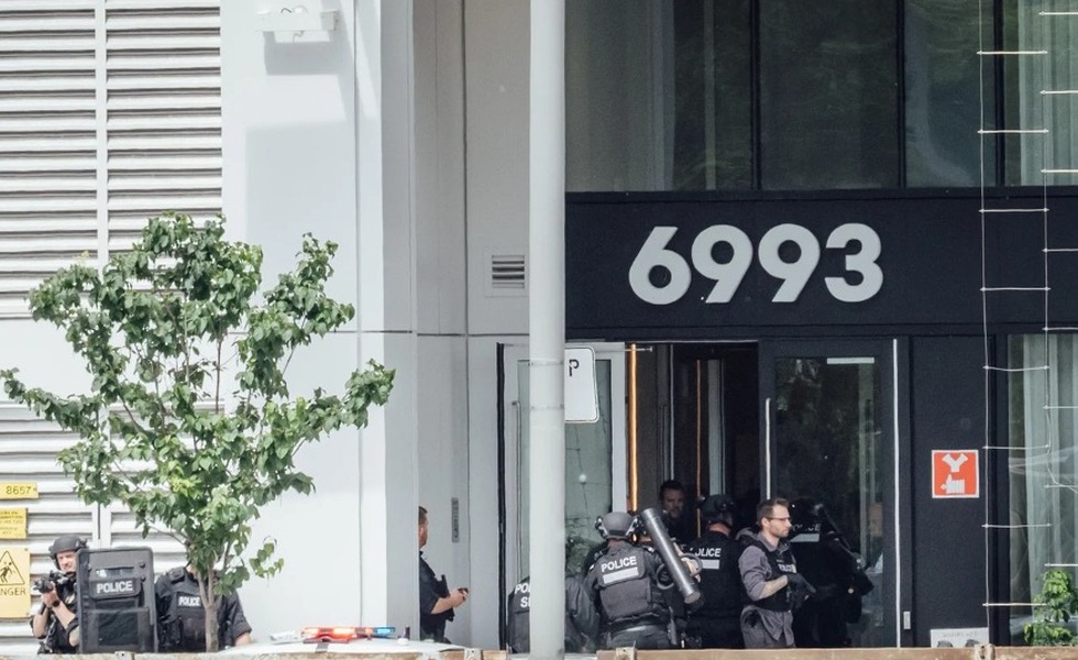 Des policiers sont déployés devant l’entrée d’un immeuble commercial portant le numéro 6993 après la fusillade du 22 juin 2026. Photo : Andrej Ivanov / AFP, publiée par Le Monde.