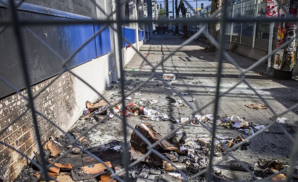 Des débris calcinés jonchent l’accès clôturé du commissariat East Precinct de Seattle après l’incendie.