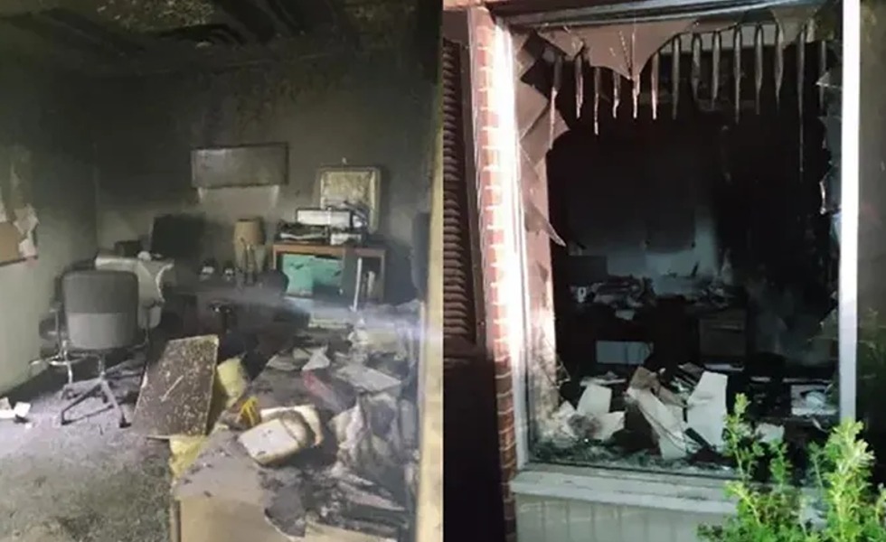 L’intérieur incendié de CompassCare apparaît derrière une vitrine brisée, avec du mobilier et des murs fortement endommagés.