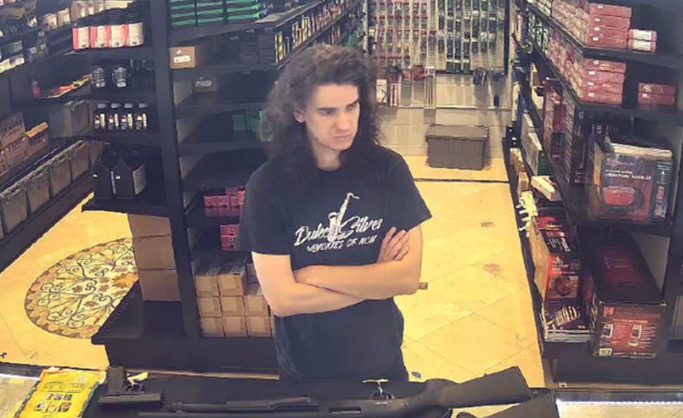 Une image de vidéosurveillance montre un homme à l’intérieur d’un commerce, devant un comptoir où sont exposées des armes longues.