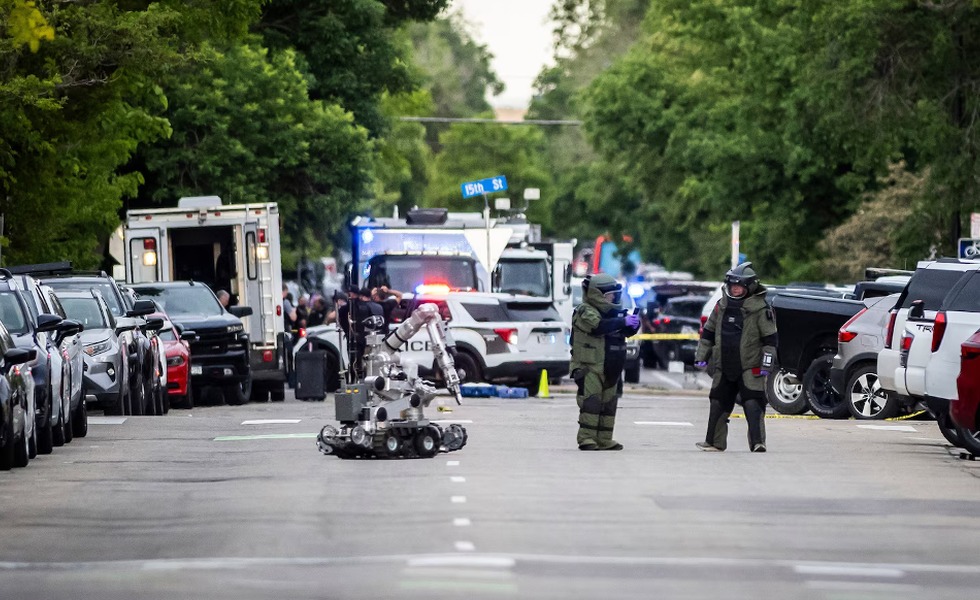 Des robots de déminage et des policiers en équipement de protection interviennent dans une rue bouclée.